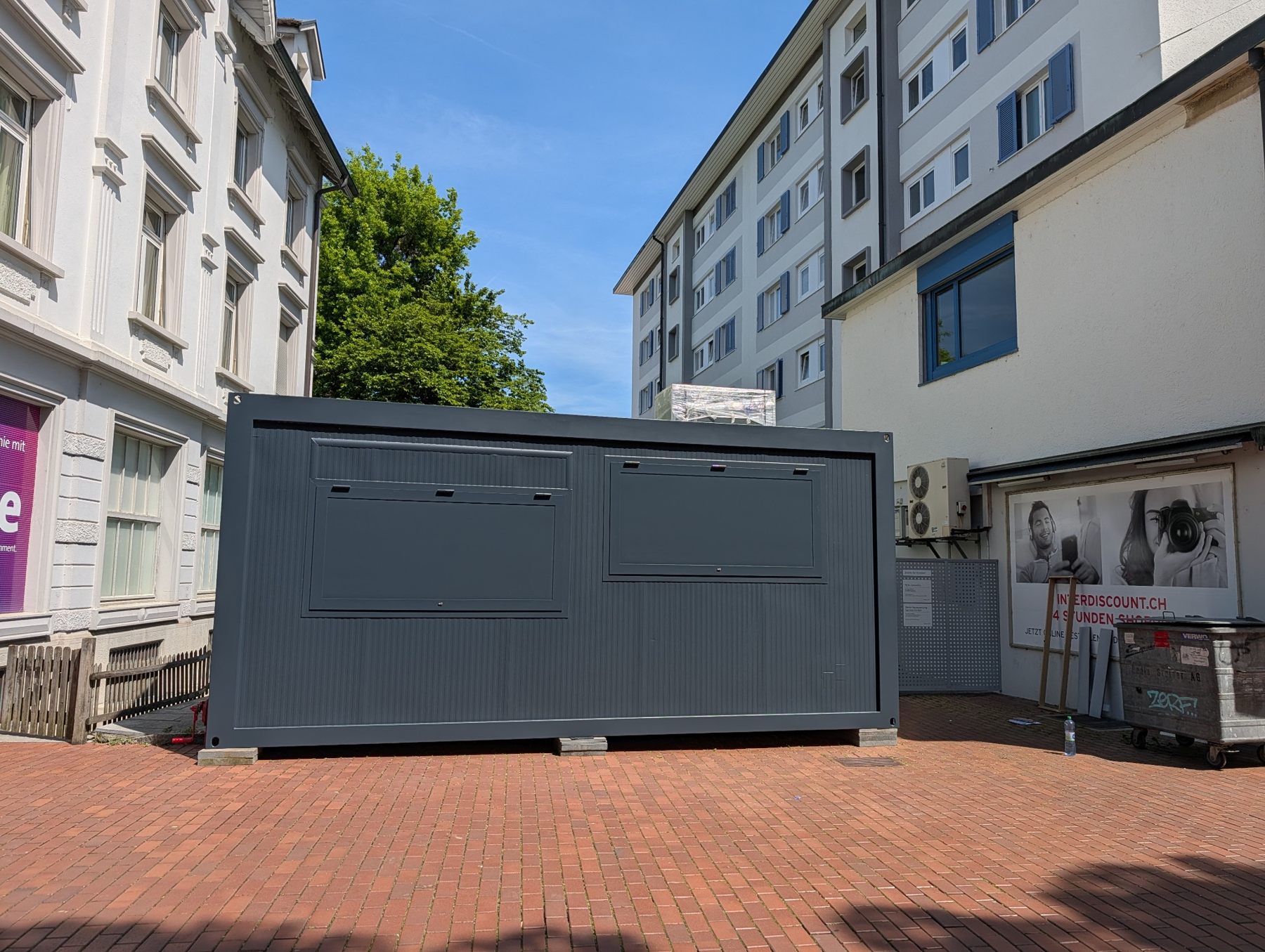 Kran hebt den schwarzen Container zur Aufstellung